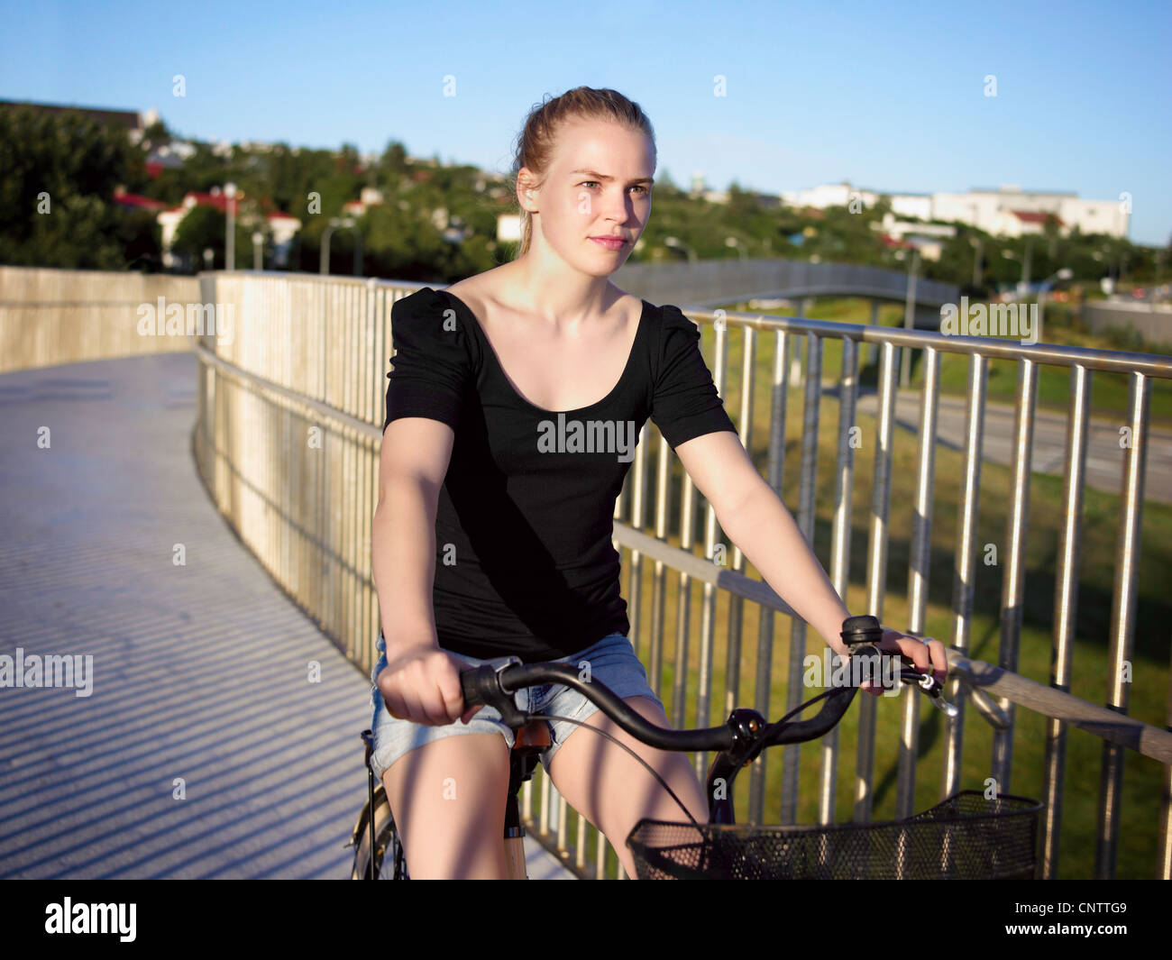Woman riding bicycle on skybridge Stock Photo
