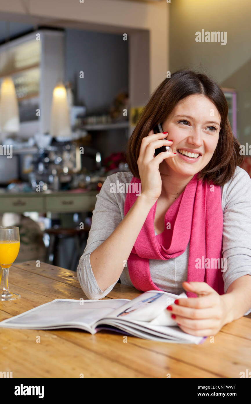 Woman talking on cell phone in cafe Stock Photo