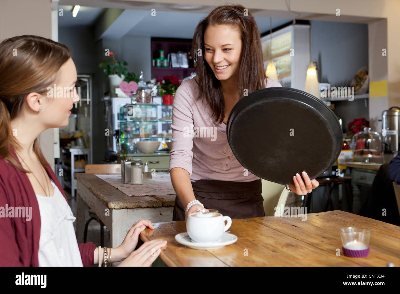 Waitress serving woman in cafe Stock Photo