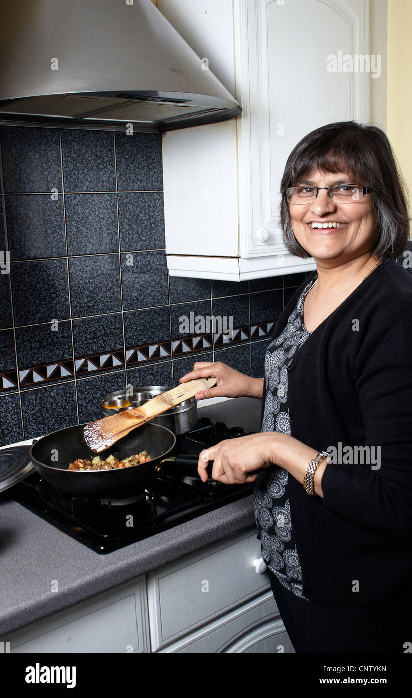 An indian lady in the kitchen making a curry Stock Photo Alamy