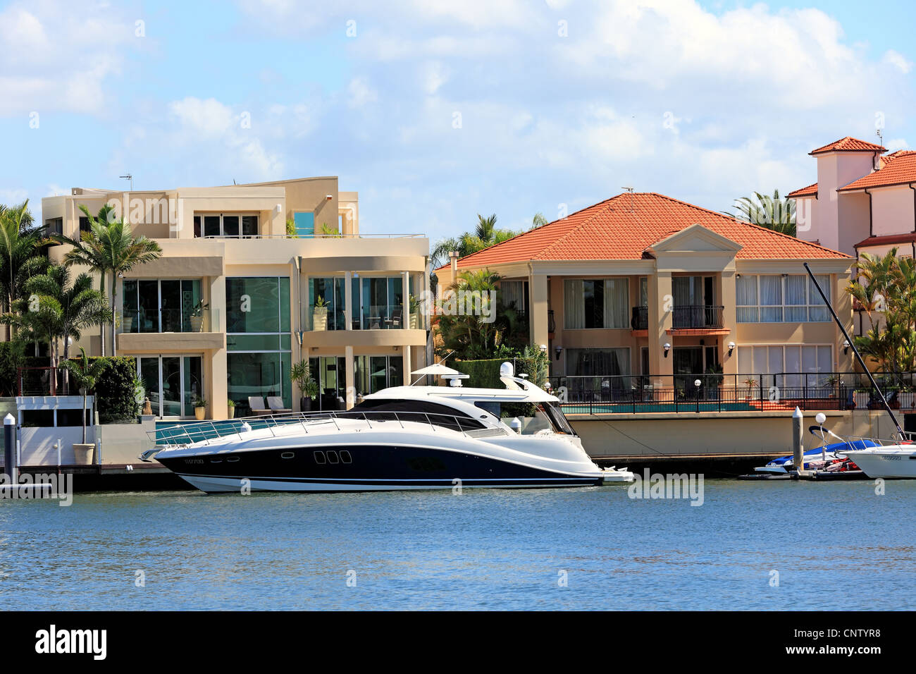 Palatial river front living 2 story mansions with luxury cruiser Stock