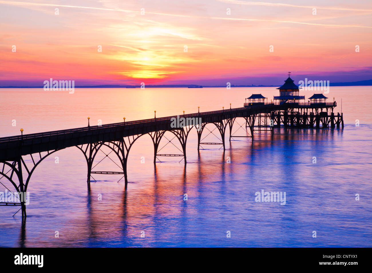 The sun sets over the Bristol Channel behind the Pier at Clevedon, Somerset, England, UK Stock Photo