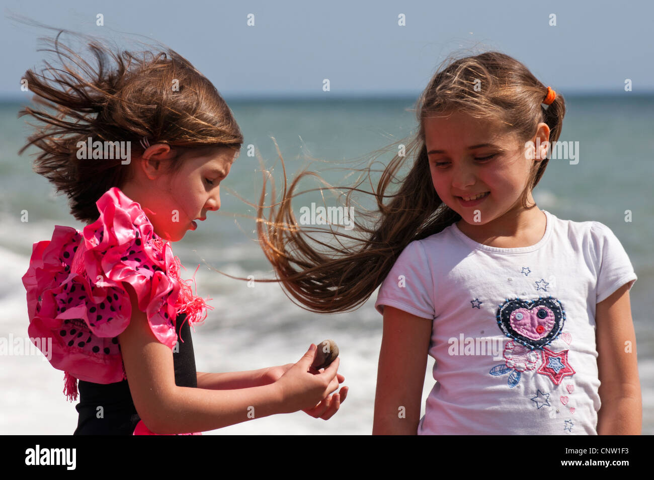 Windswept girls on the beach Stock Photo