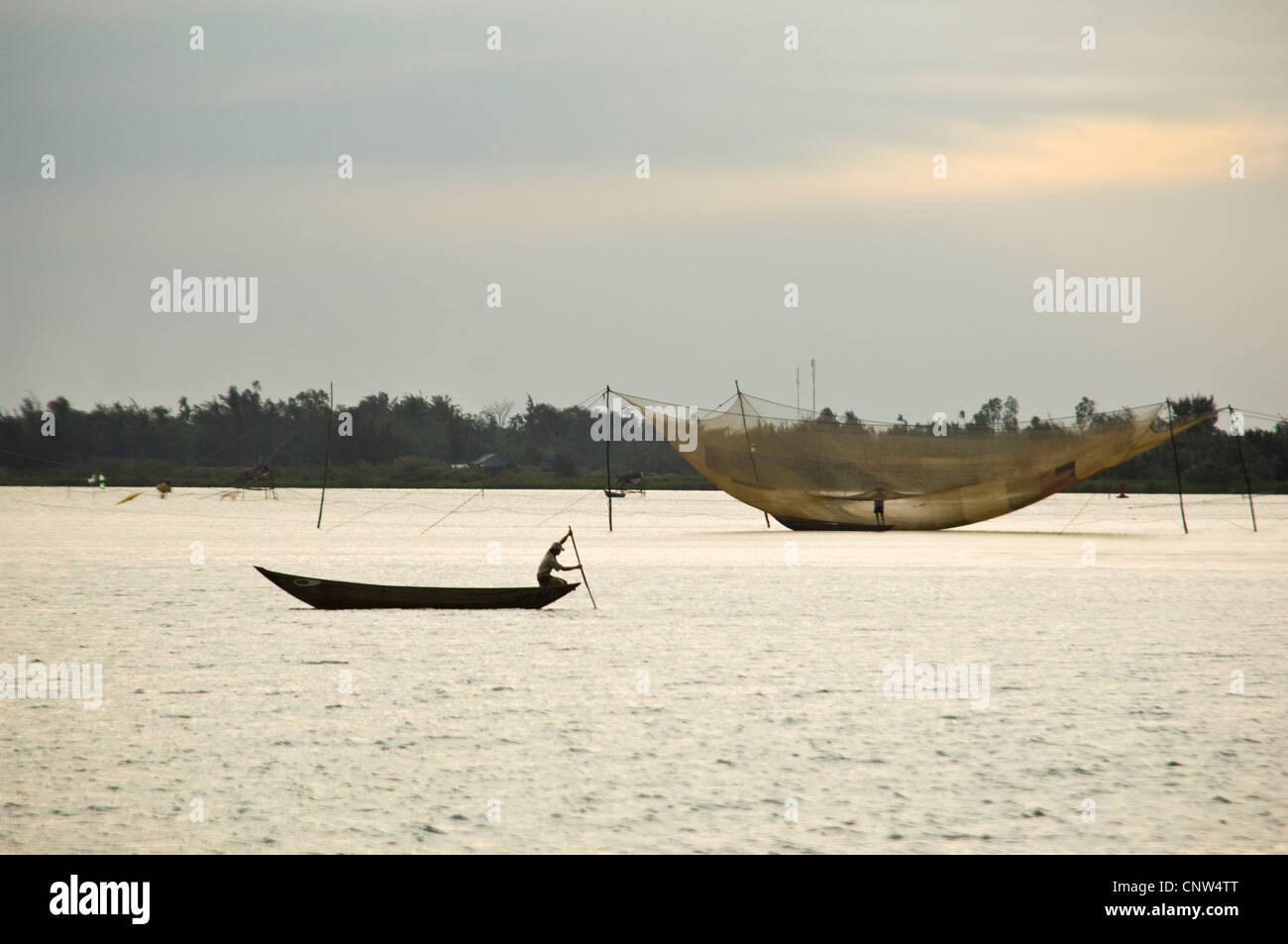 Horizontal view of empty fishing nets, lưới cá, waiting to be lowered into the Mekong Delta overnight. Stock Photo