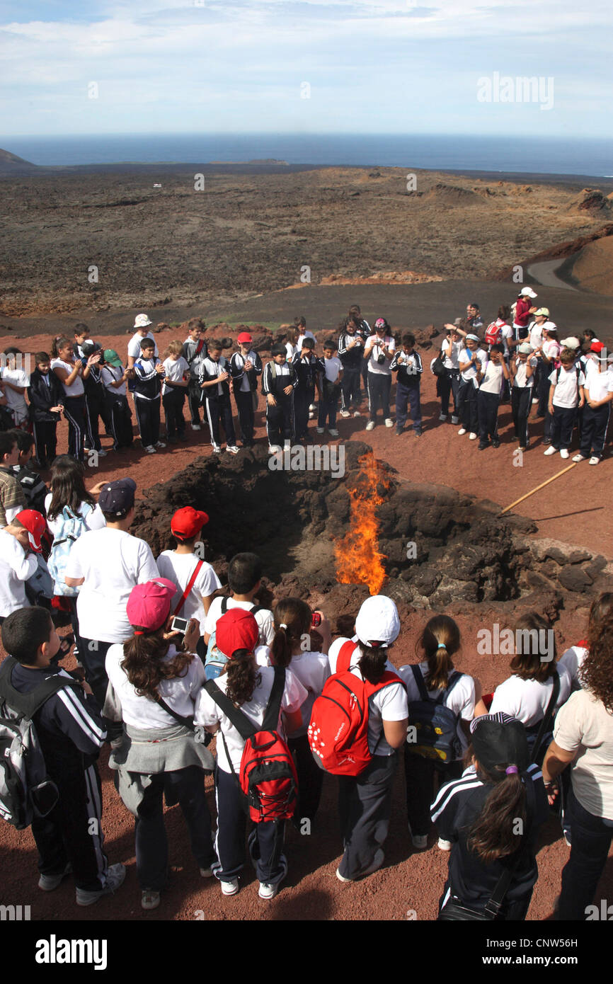 emblazing a bale of hay by the subterranean heat in front of lots of visitors of the volcanic mountains, Canary Islands, Lanzarote, Timanfaya National Park Stock Photo