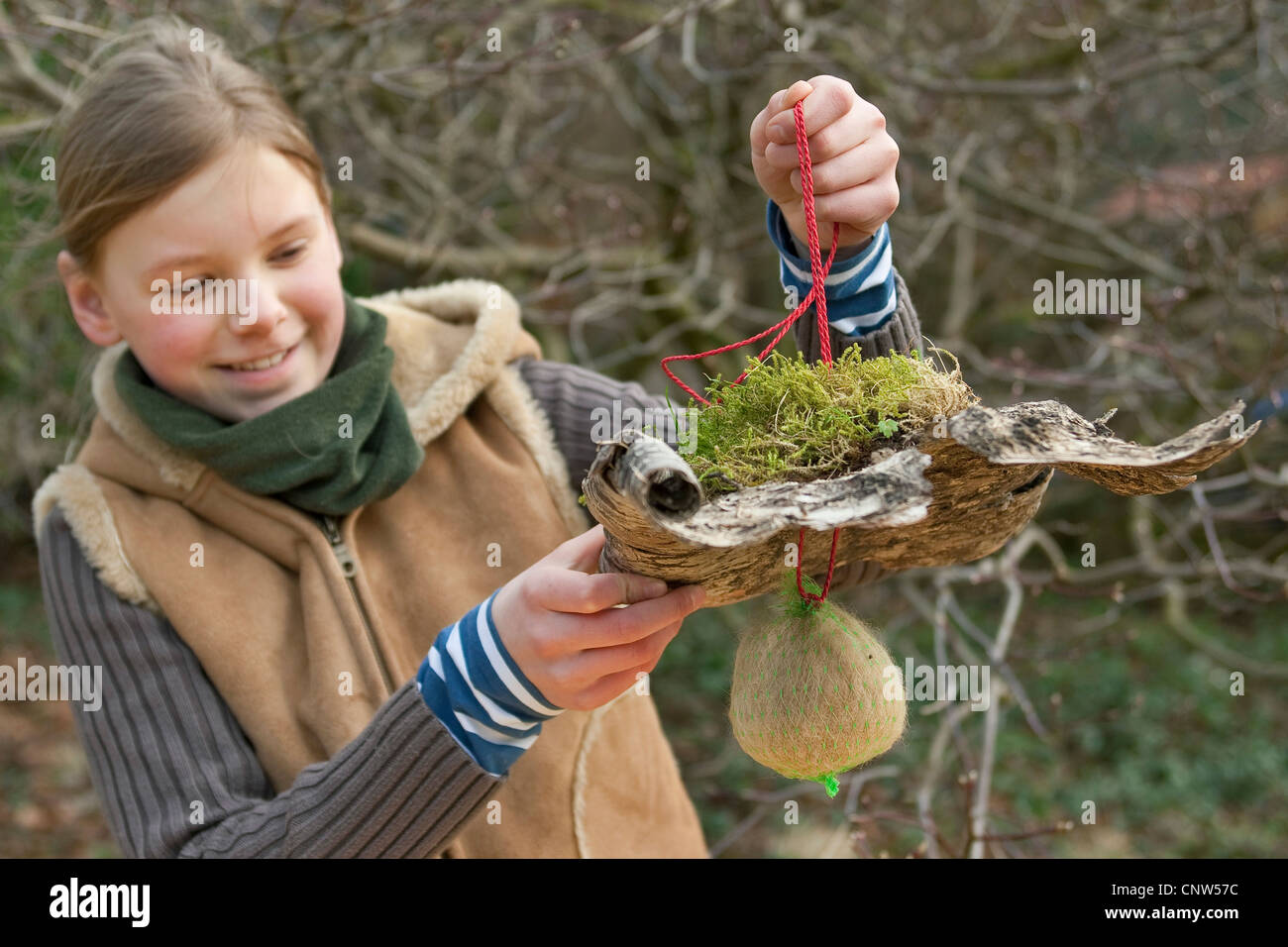 girl presenting a self-made dispenser for nesting material Stock Photo