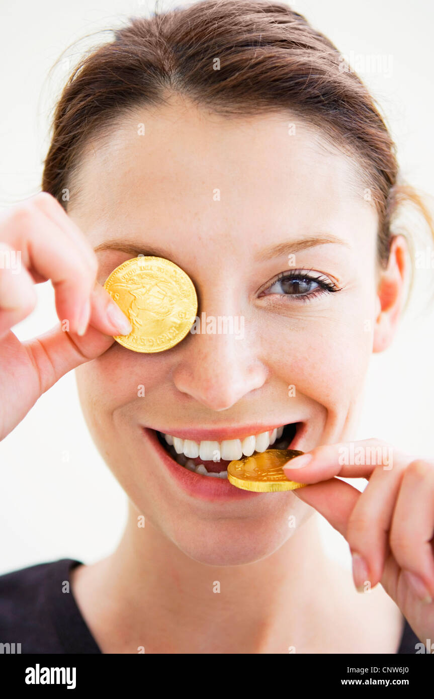 Woman playing with gold coins Stock Photo