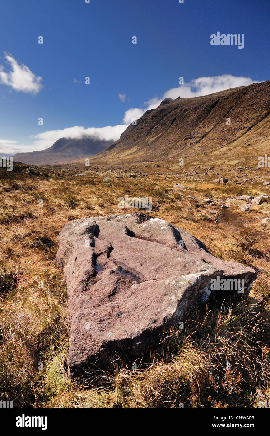 Sandstone rock in the Torridon glen of Coire Mhic Nobuil. Beinn Dearg and Beinn Alligin in the background Stock Photo