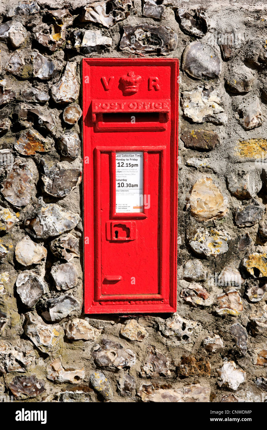 British Red Victorian Mail box embedded in a flint stone wall Stock Photo