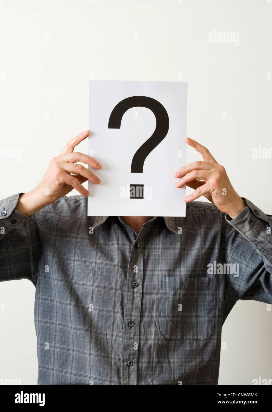 Man with question mark covering face. Stock Photo