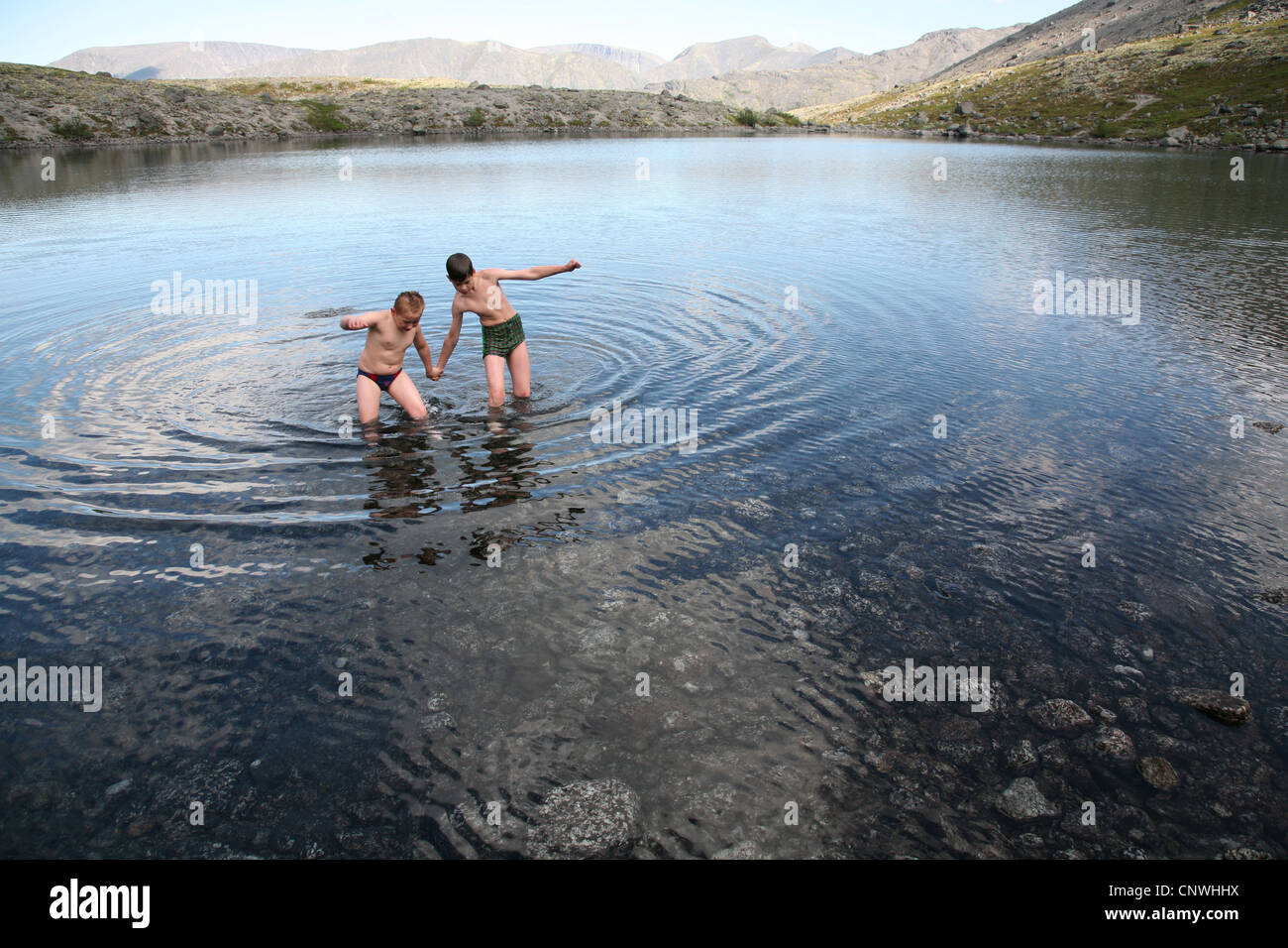 Children swim in the mountain lake in the Khibiny Mountains on Kola ...