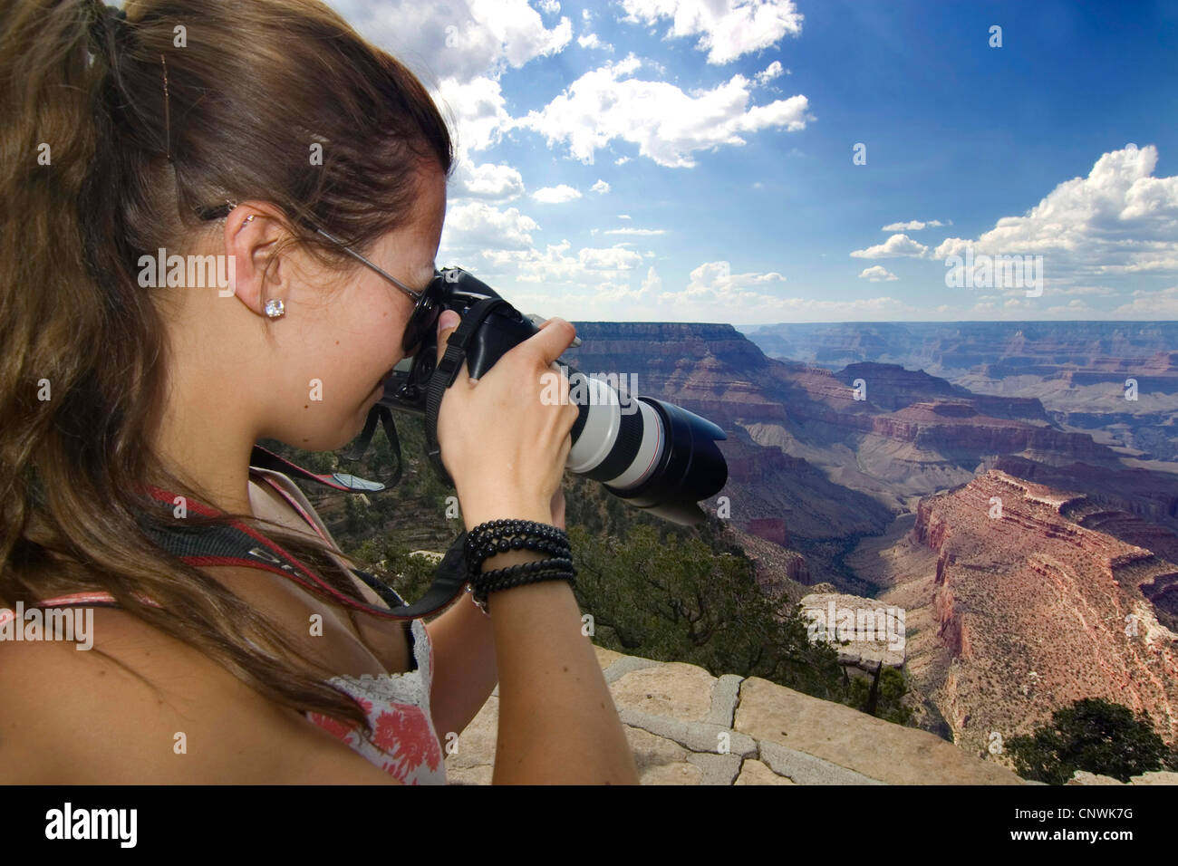 young female tourist taking a picture of the Grand Canyon from the ...