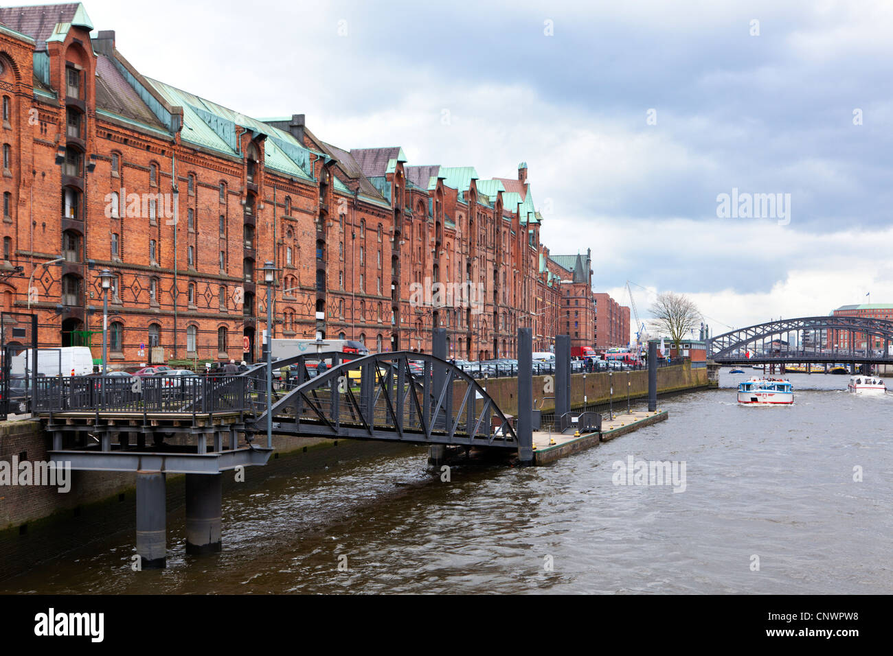 Historic warehouses at the Speicherstadt Hamburg, harbor tour boats on the canal Stock Photo