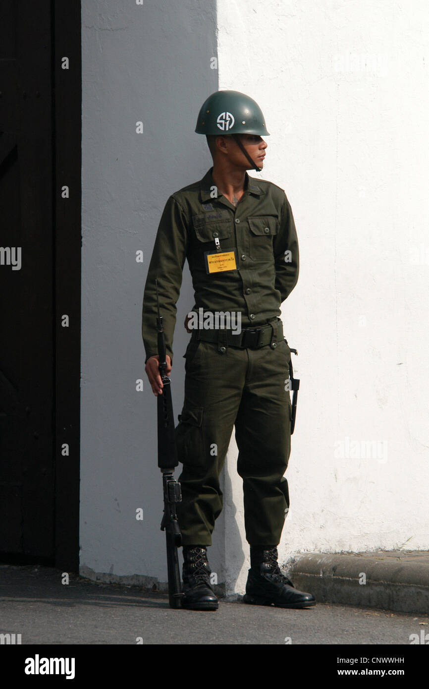 Thai policeman guards the Royal Palace in Bangkok, Thailand Stock Photo