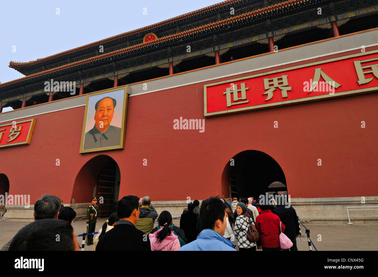 People queue for entrance below the portrait of Chairman Mao on the outer gate to the Forbidden City, Beijing, China. Stock Photo