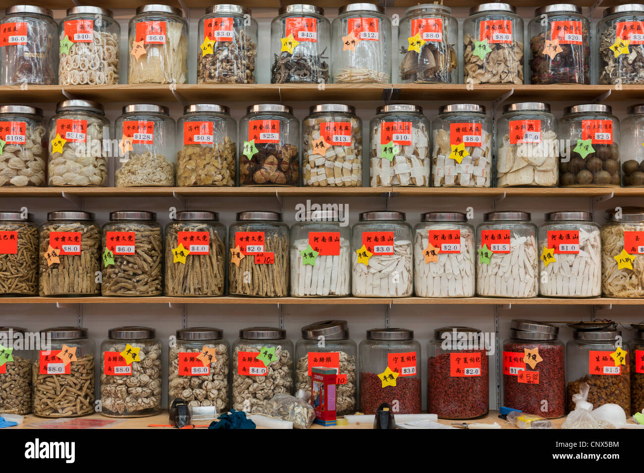 Chinese herbal medicine in glass jars on shelves Stock Photo