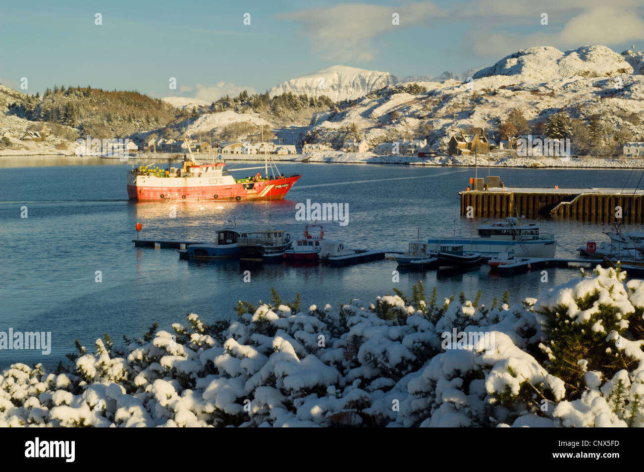 Ship approaching harbour at Lochinver village, Sutherland, Scottish Highlands in winter Stock Photo