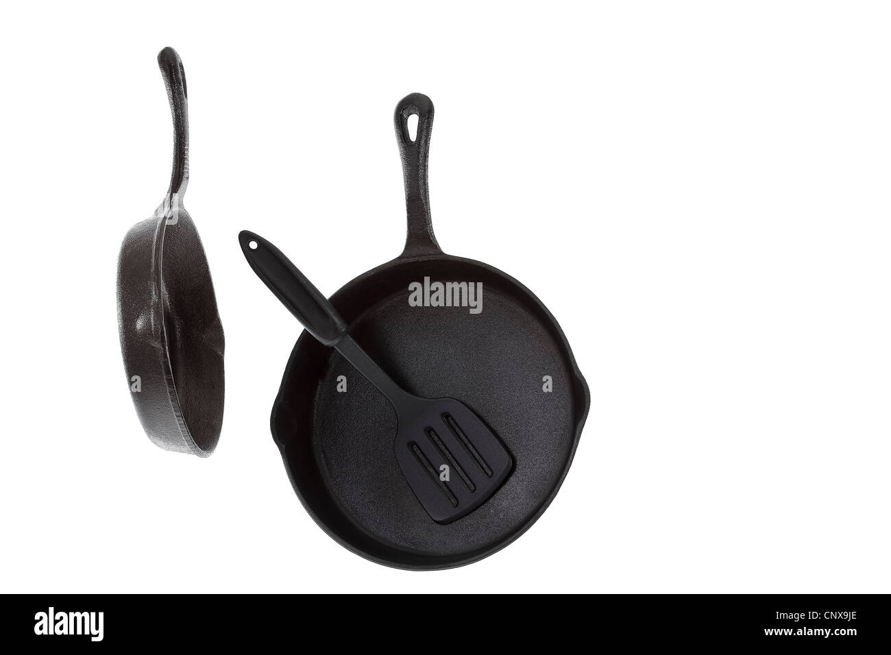 Two Cast Iron Frying Pans with spatula isolated on white Stock Photo