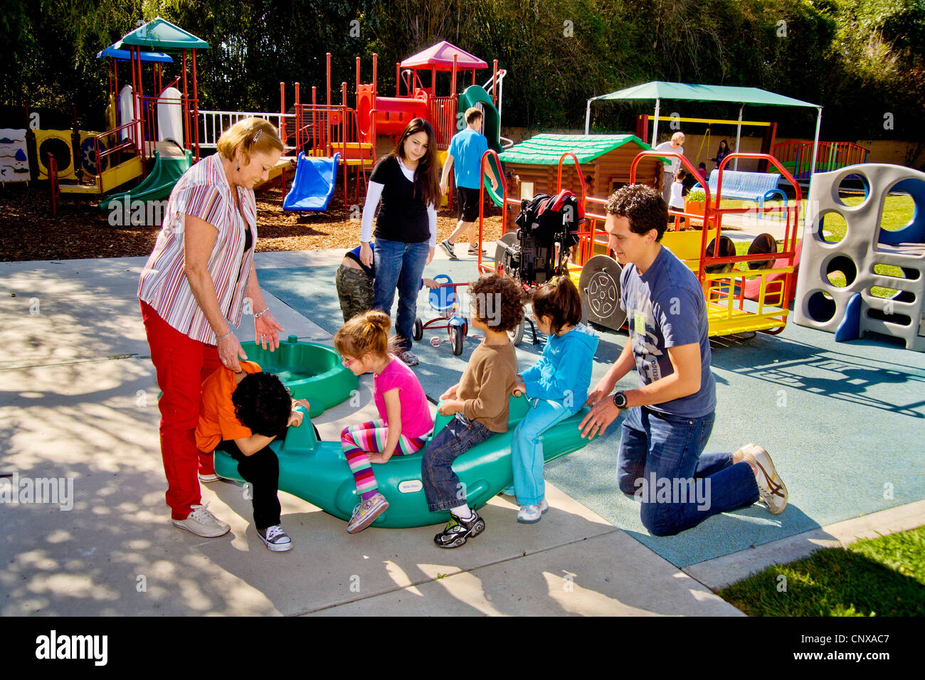 Young and old staff members help blind and crippled children use the playground at the Blind Childrens Learning Center. Stock Photo