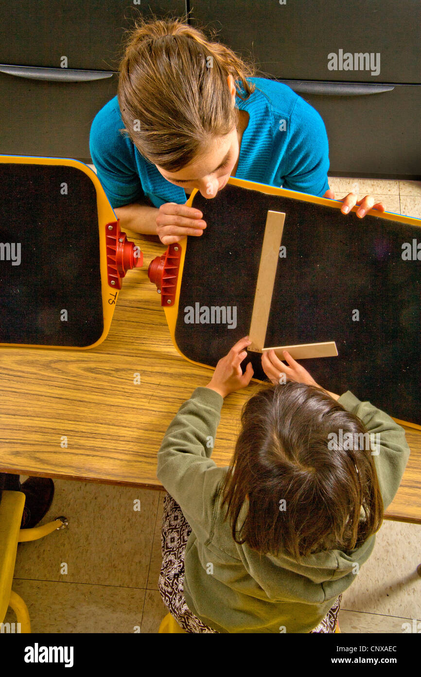 The teacher in a special needs pre-Braille writing class at the Blind Children's Learning Center starts with 'L'. Stock Photo