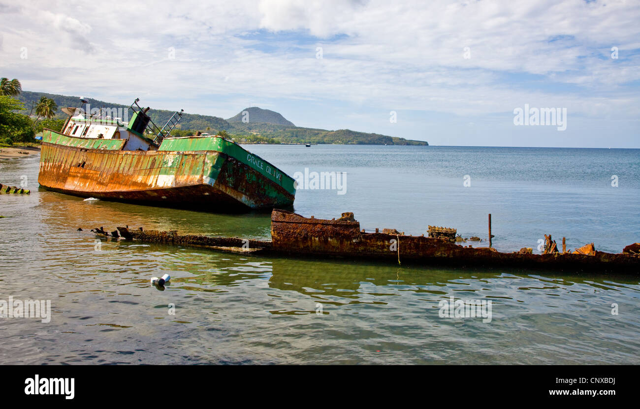 Two of the corroding hulks of ships that litter Prince Rupert's Bay near Portsmouth in Dominica West Indies Stock Photo