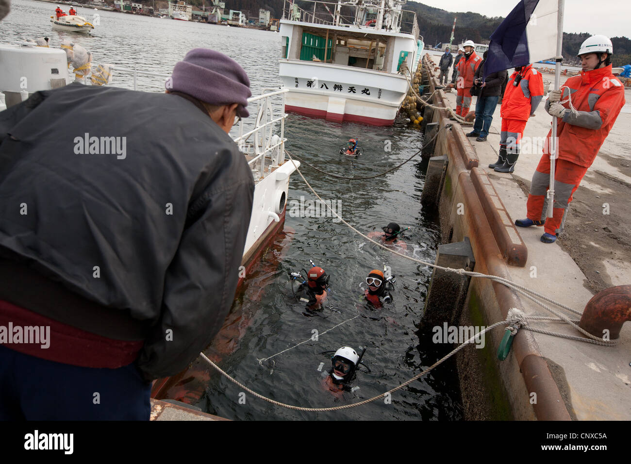 Japanese coast guard search underwater for the bodies of victims of the March2011 tsunami, in Kesennuma harbour, Tohoku, Japan. Stock Photo