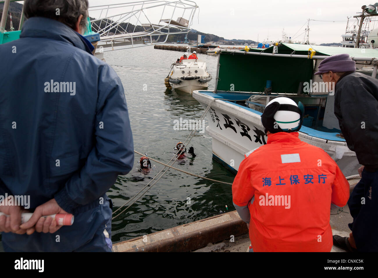 Japanese coast guard search underwater for the bodies of victims of the March2011 tsunami, in Kesennuma harbour, Tohoku, Japan. Stock Photo