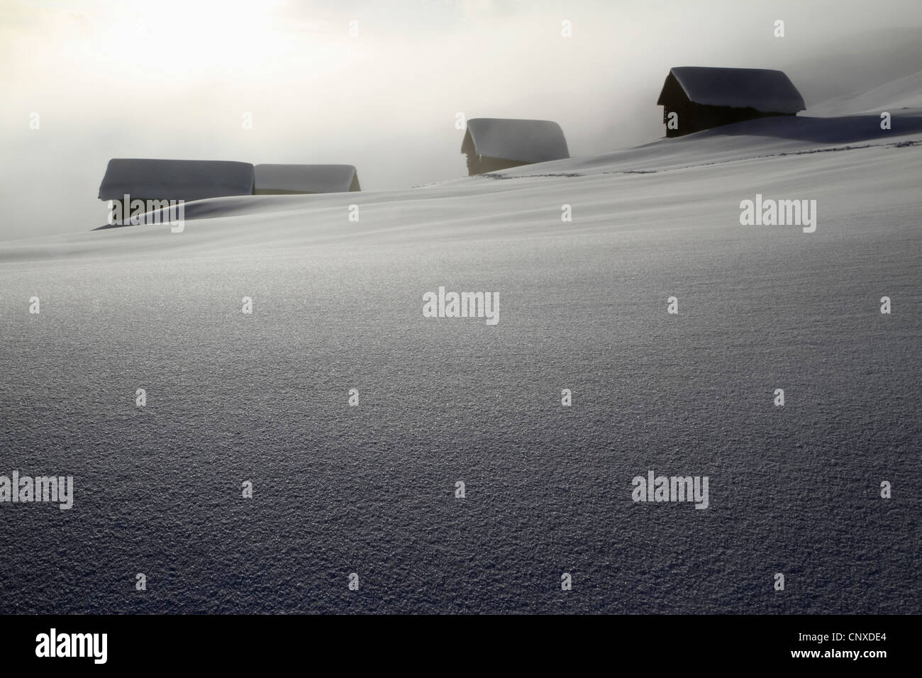Four log cabins on smooth snowy landscape Stock Photo - Alamy