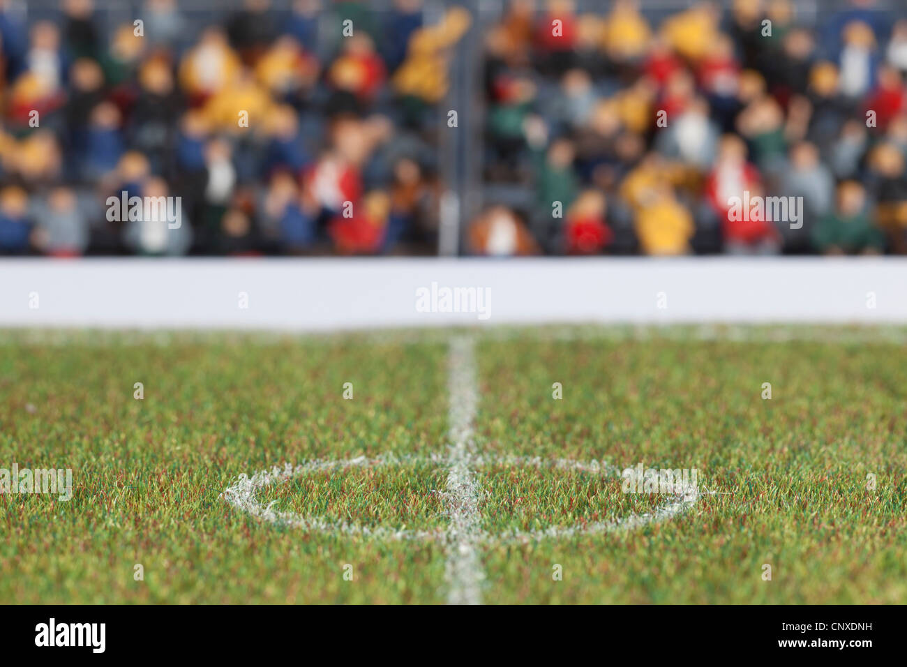 The center field of a miniature soccer field, spectator figurines in background Stock Photo
