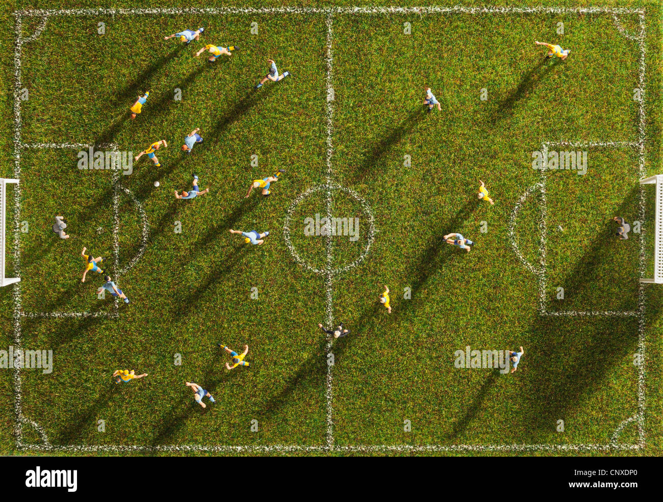 Miniature figurines of two soccer teams playing a soccer match, directly above Stock Photo
