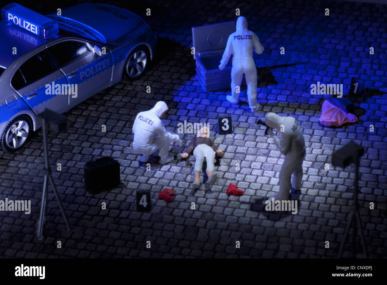 A diorama of a miniature forensics team collecting evidence at a murder scene Stock Photo