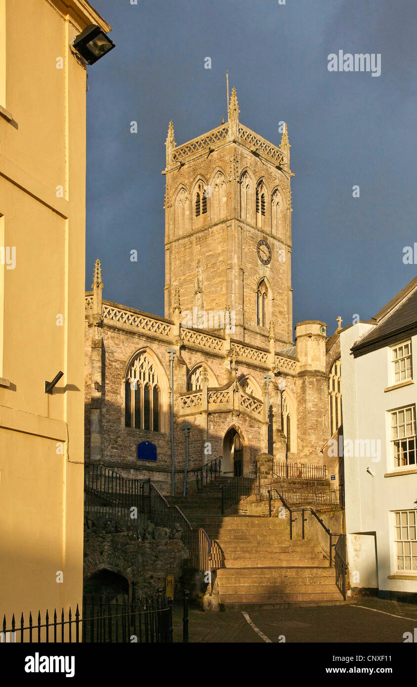 Church of St John the Baptist from the market square in Axbridge Somerset in evening light with grey cloud Stock Photo