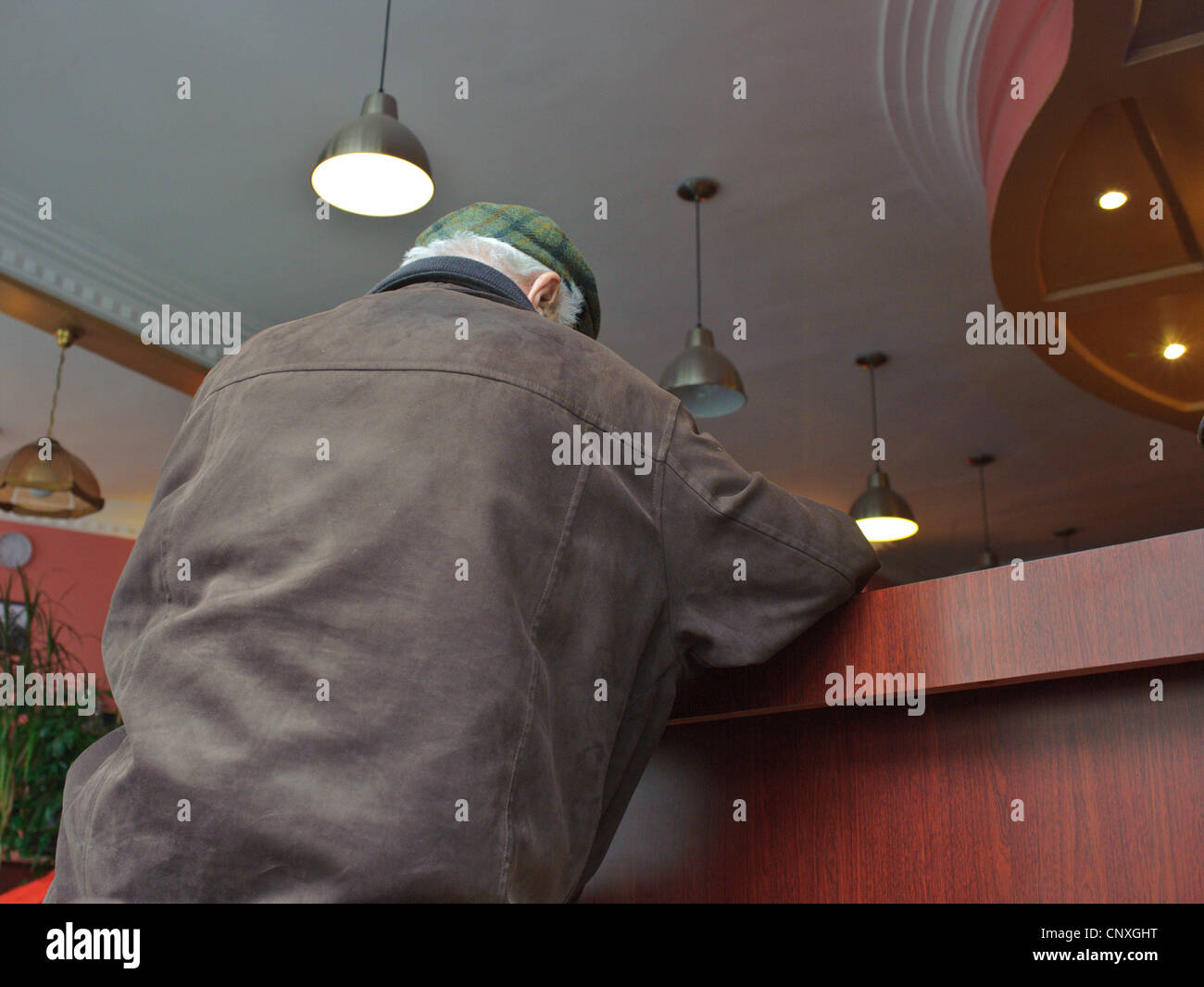 Older man sitting at coffee bar in Paris Stock Photo