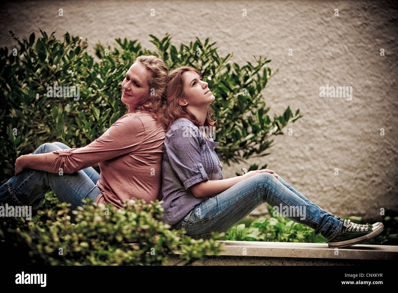 mother and daughter sitting in the back garden Stock Photo