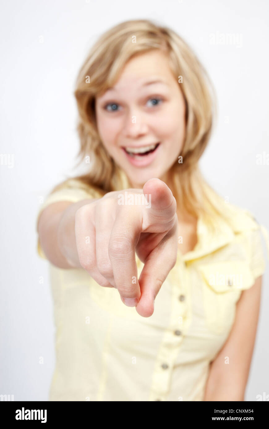 Young beautiful woman points with her finger toward the viewer. Stock Photo