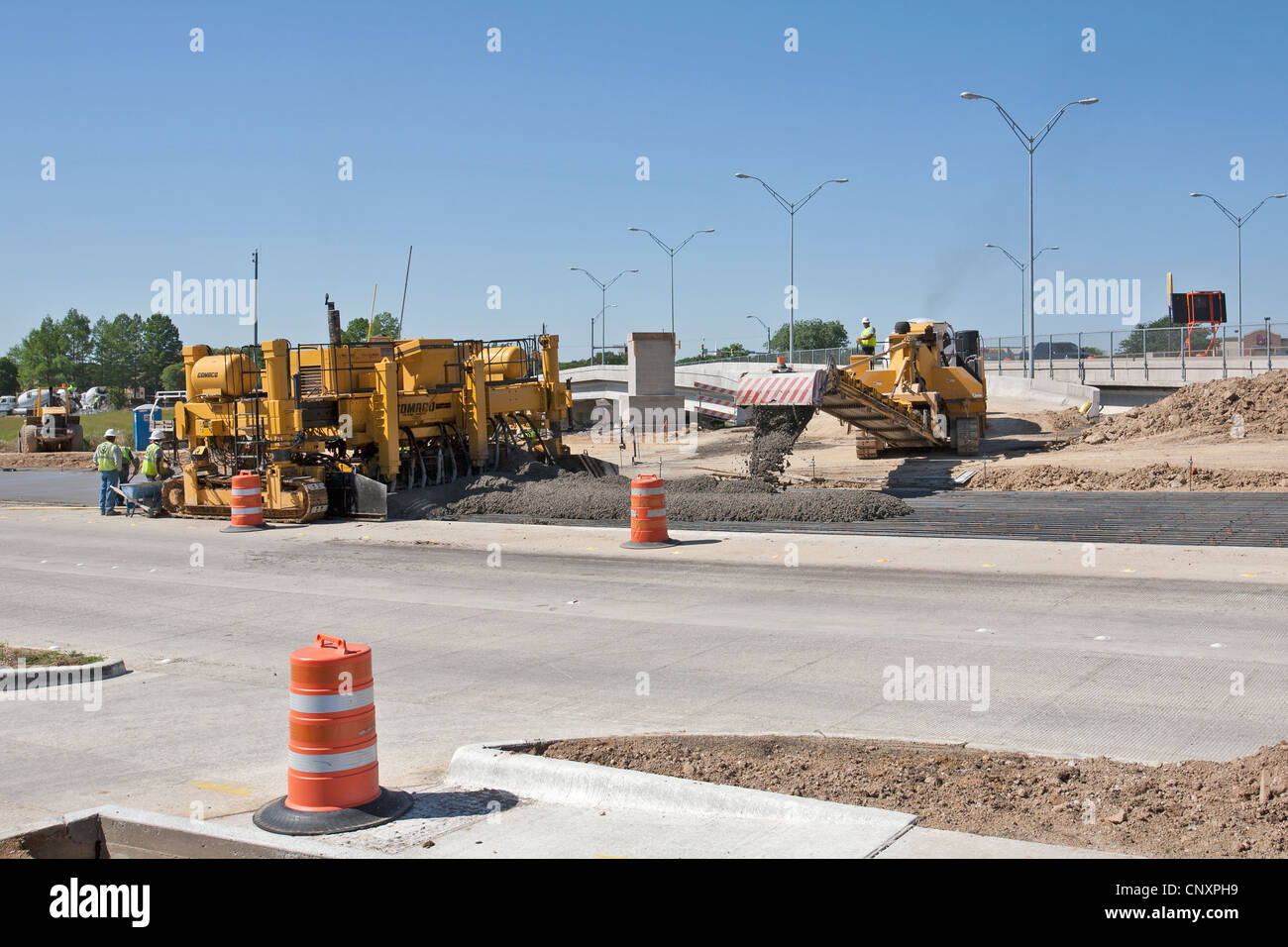 Streets are constructed by using a fluid concrete mix as workers hurry in making final touches before the concrete sets up. Stock Photo