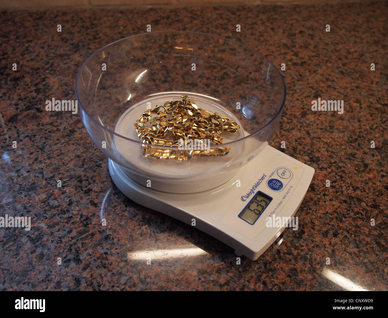A gold necklace being weighed on a food 