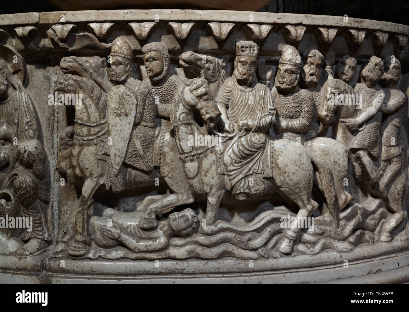 Church of San Frediano, Lucca, Italy. Detail of medieval horsemen and knights on 12th century Romanesque baptismal font Stock Photo
