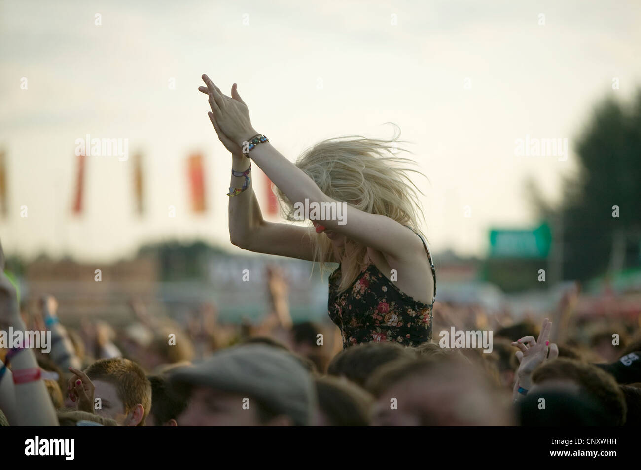 Girl clapping on shoulders in a crowd at Reading music festival. Stock Photo