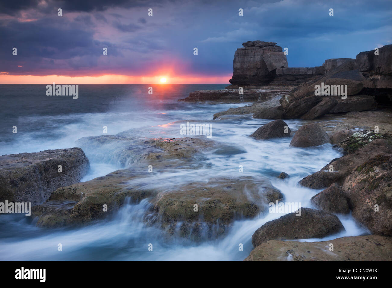 Waves break over the rocky shoreline of Portland Bill, Isle of Portland, Dorset, England. Spring (April) 2012. Stock Photo