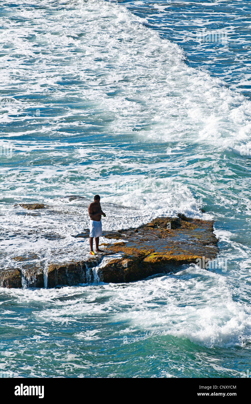 fisherman standing on a rock in the surf, Saint Vincent and the Grenadines, Biabou Bay Stock Photo