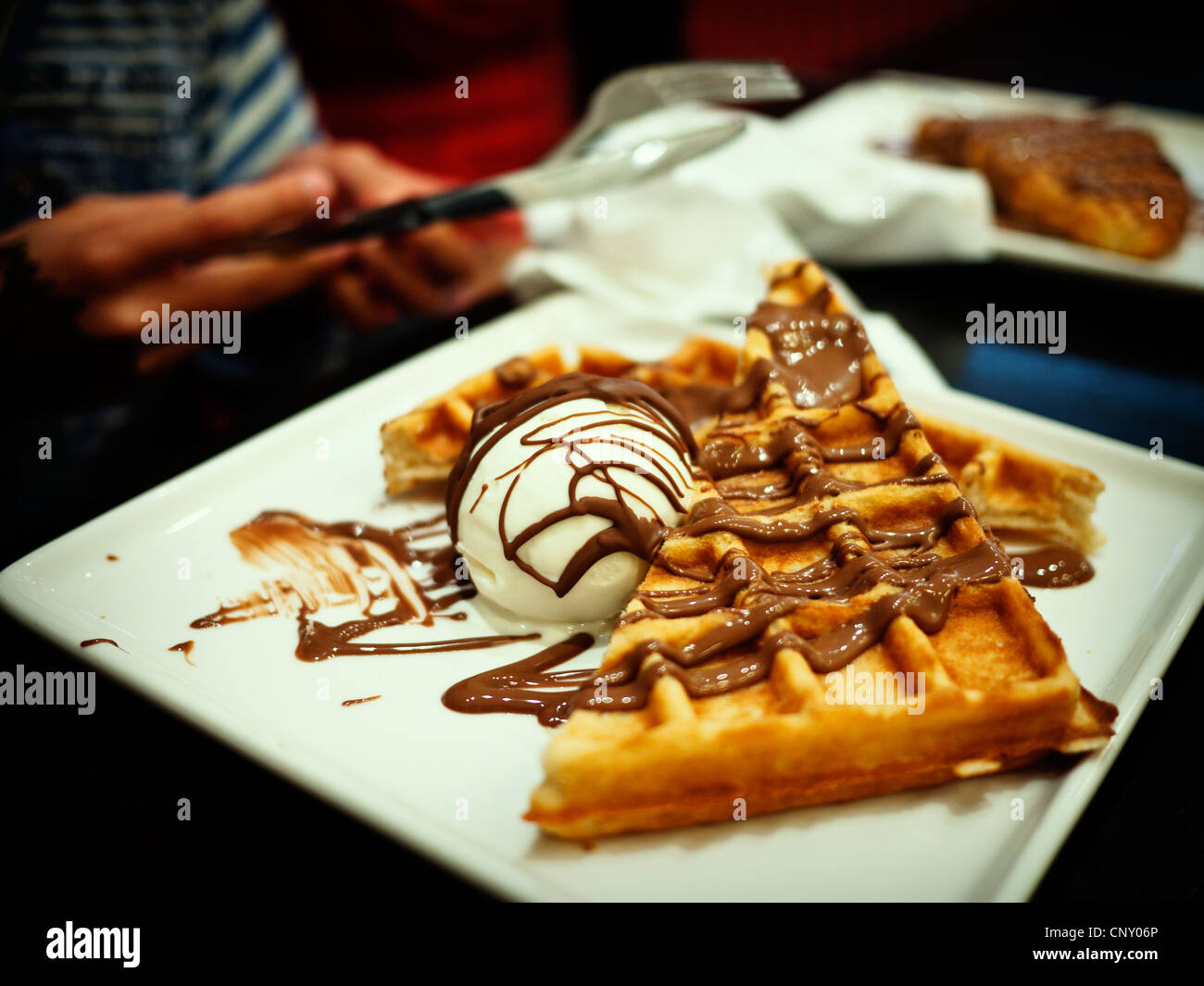 Halfway through waffles with icecream and choclate sauce Stock Photo