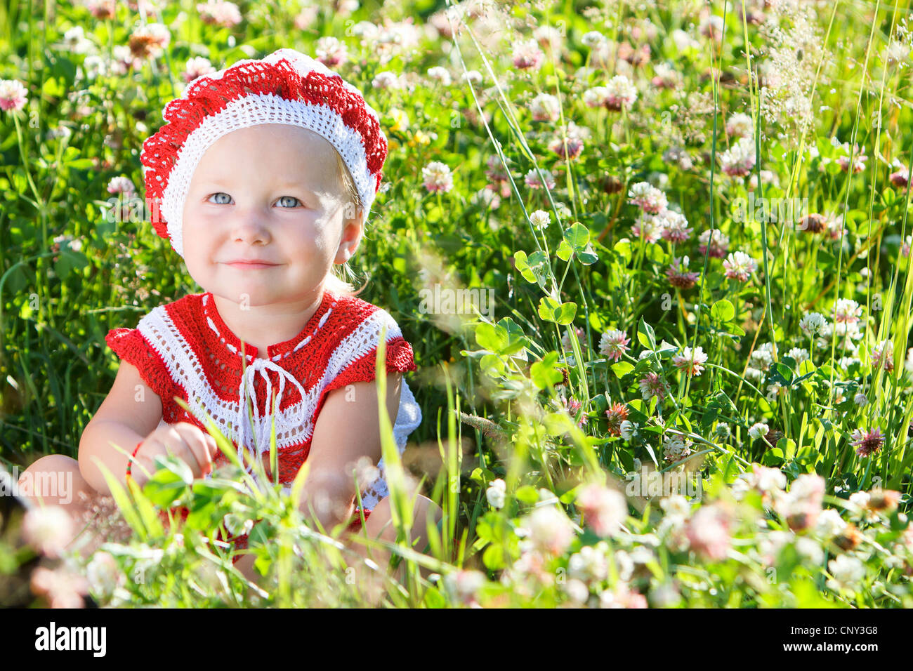 Happy girl sitting in a field hi-res stock photography and images - Alamy