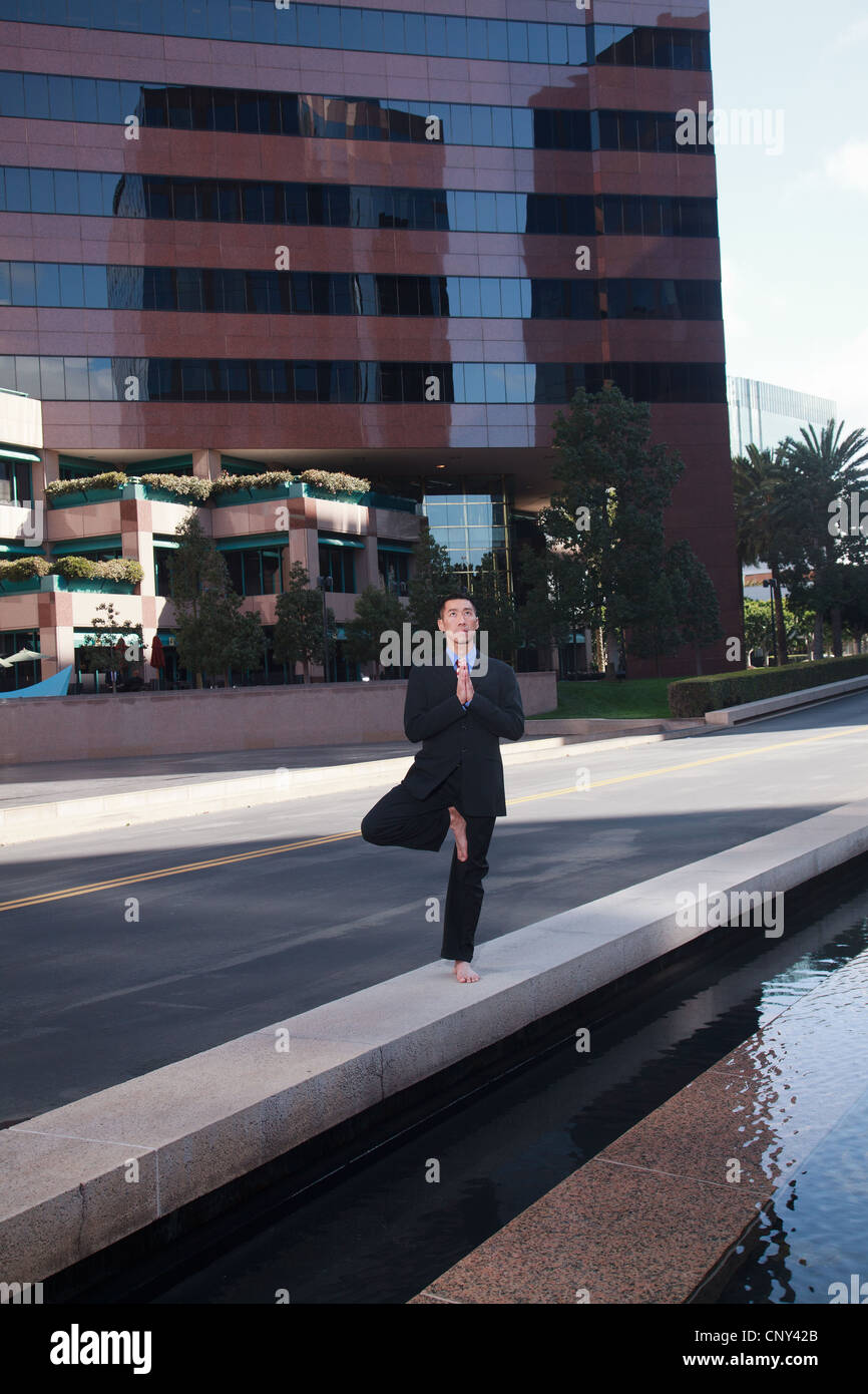 Businessman practicing yoga and meditation Stock Photo - Alamy