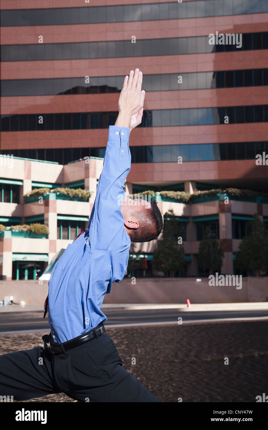 Businessman practicing yoga and meditation in business park with high ...