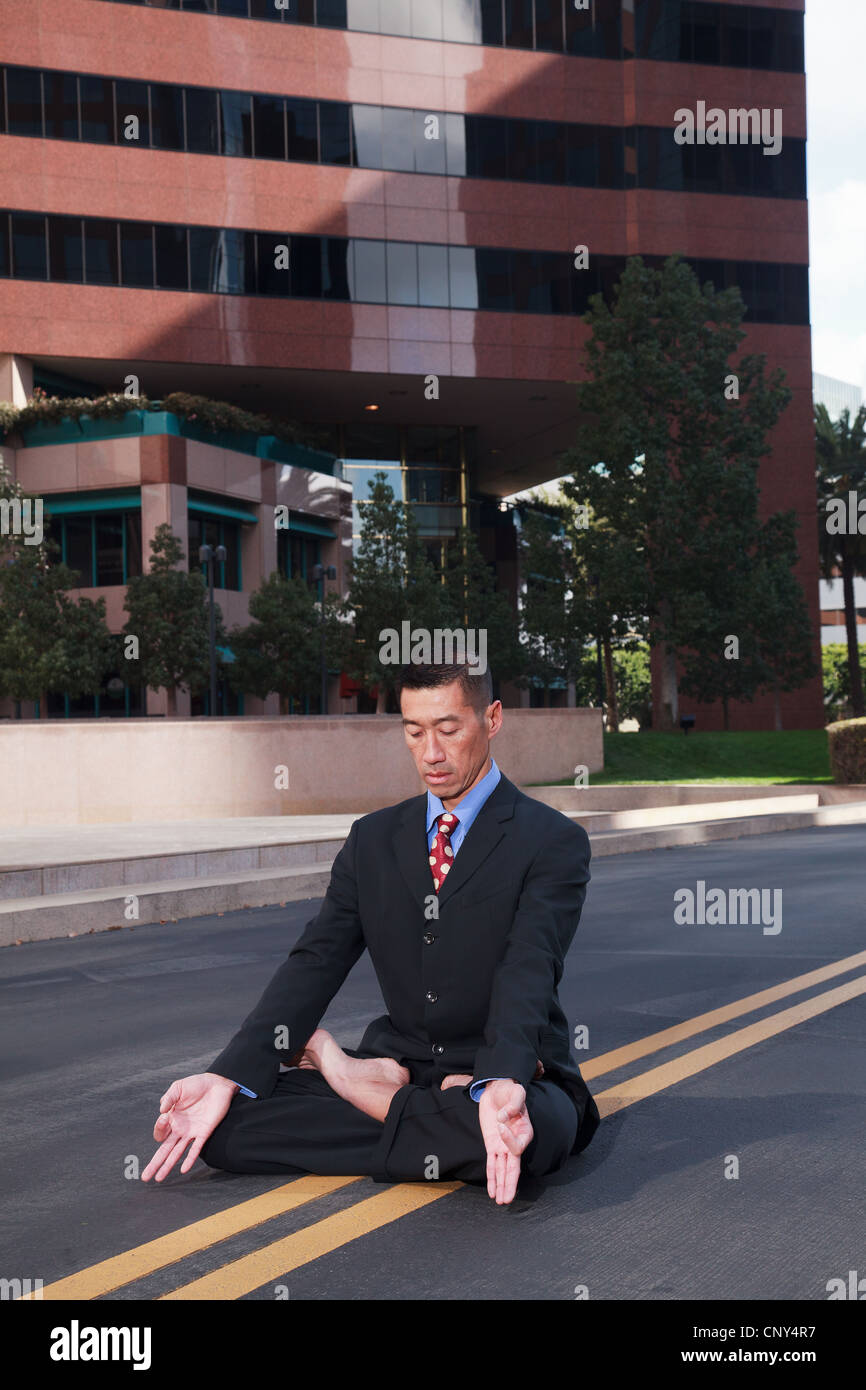 Businessman practicing yoga and meditation. Stock Photo