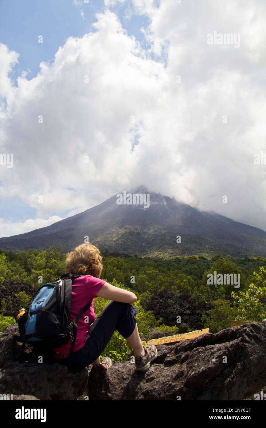 Female tourist contemplating smoking Arenal Volcano, Costa Rica, Central America Stock Photo