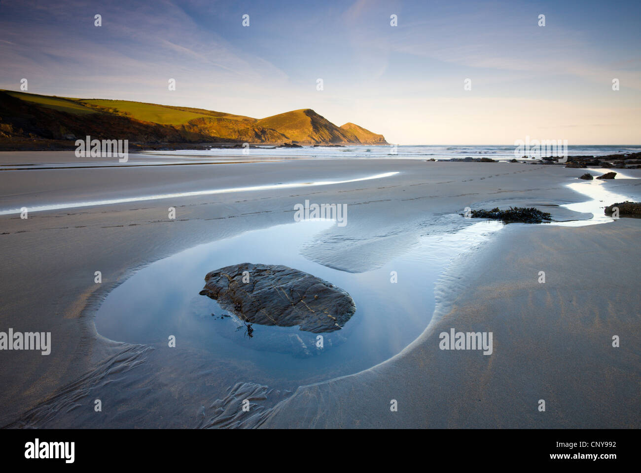 Exposed rockpool at low tide on a deserted beach at Crackington Haven, Cornwall, England. April 2009 Stock Photo