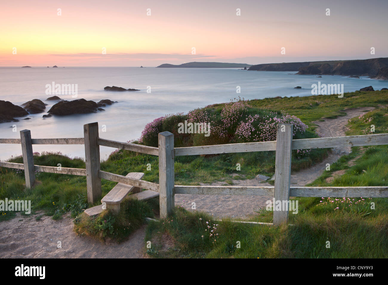 Wooden stile on a clifftop footpath, part of the South West Coast Path trail. Views behind to Trevose Head, Cornwall Stock Photo