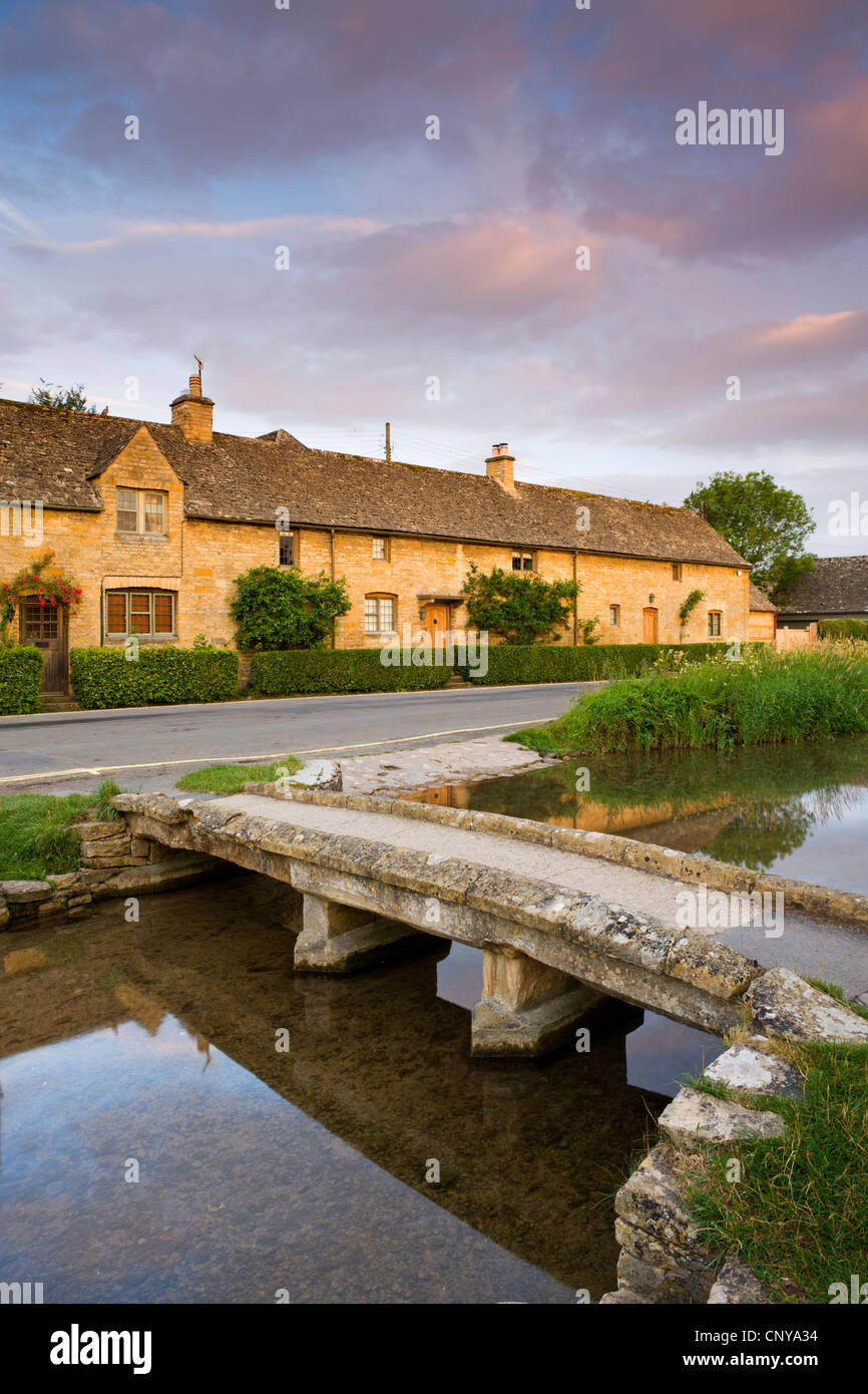 Footbridge and cottages in the picturesque Cotswold village of Lower Slaughter, Gloucestershire, England. Summer 2011. Stock Photo